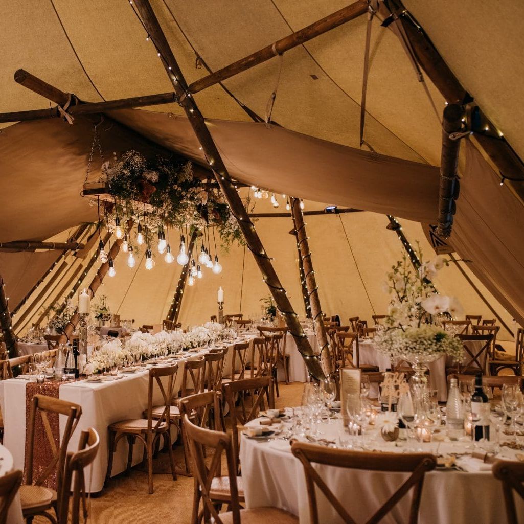 Elegant wedding reception setup inside a decorated tipi tent