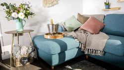 Living area with with vase of flowers, and bucket with champagne on sofa