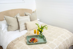 Tray with breakfast and flowers on bed