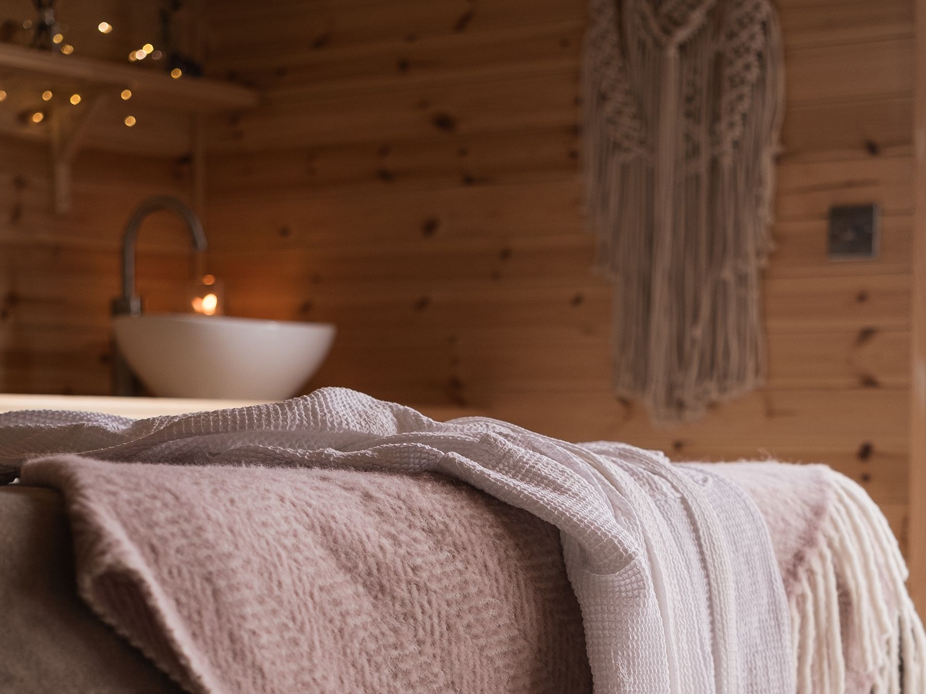 Blankets on bed in spa treatment room with soft lighting