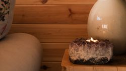 Candle and vase of dried flowers on table