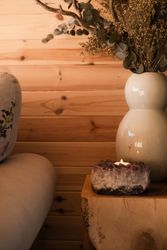 Candle and vase of dried flowers on table