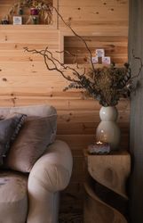 Candle and vase of dried flowers on table