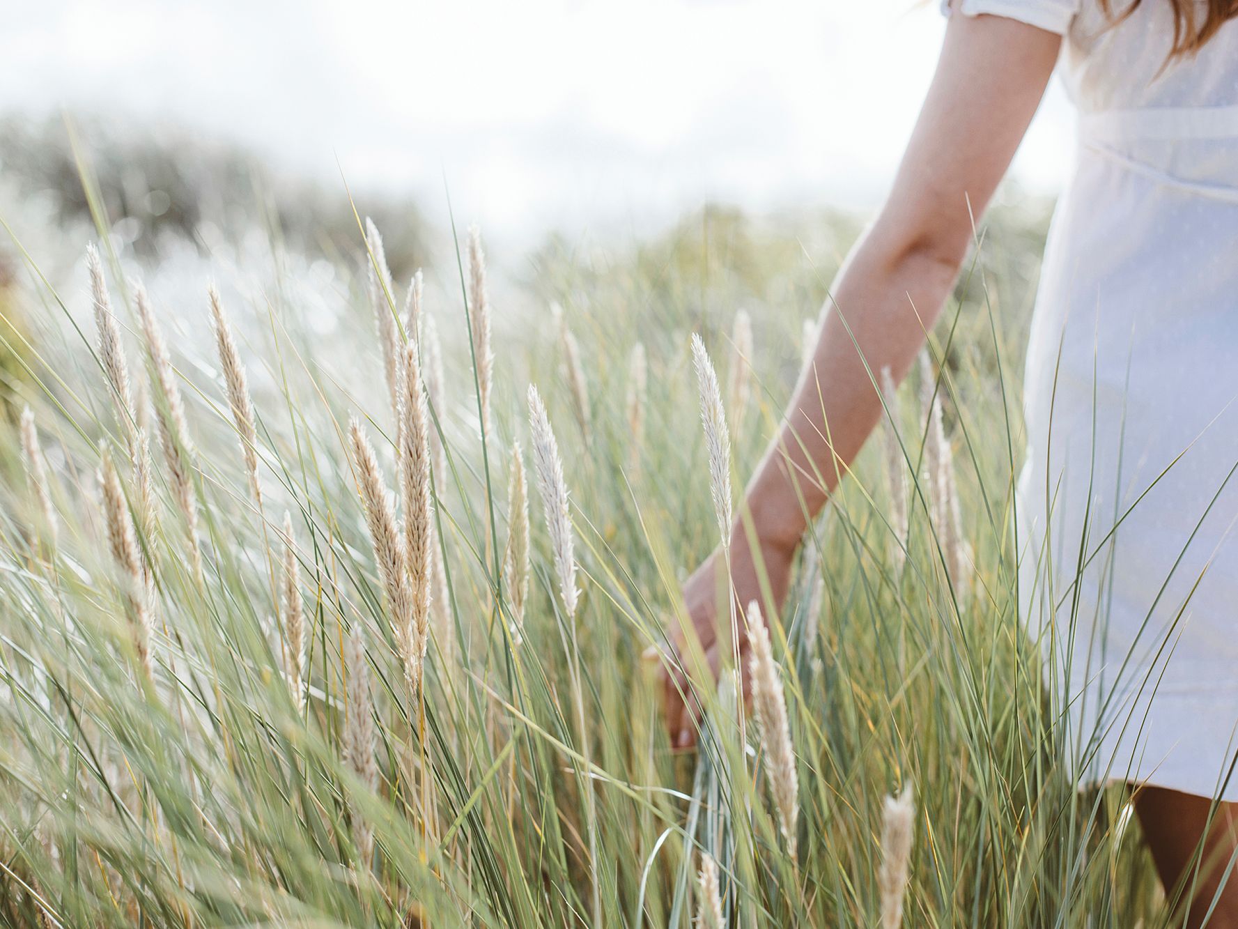 Woman walking through long grasses