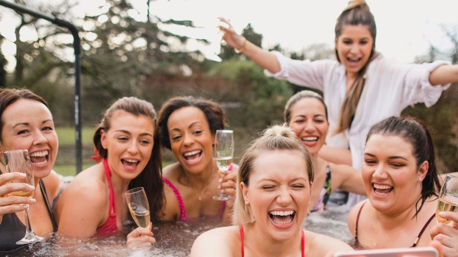 Group of girls with champagne in hot tub