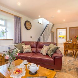 Living Area in Towy cottage with leather sofas and a dining table with 6 chairs