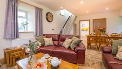Living Area in Towy cottage with leather sofas and a dining table with 6 chairs