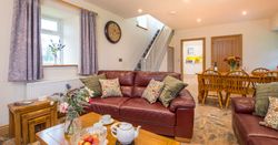 Living Area in Towy cottage with leather sofas and a dining table with 6 chairs