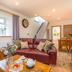 Living Area in Towy cottage with leather sofas and a dining table with 6 chairs