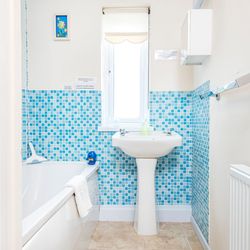 Bathroom in Cothi Cottage with bath and bright blue tiles