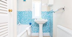 Bathroom in Cothi Cottage with bath and bright blue tiles
