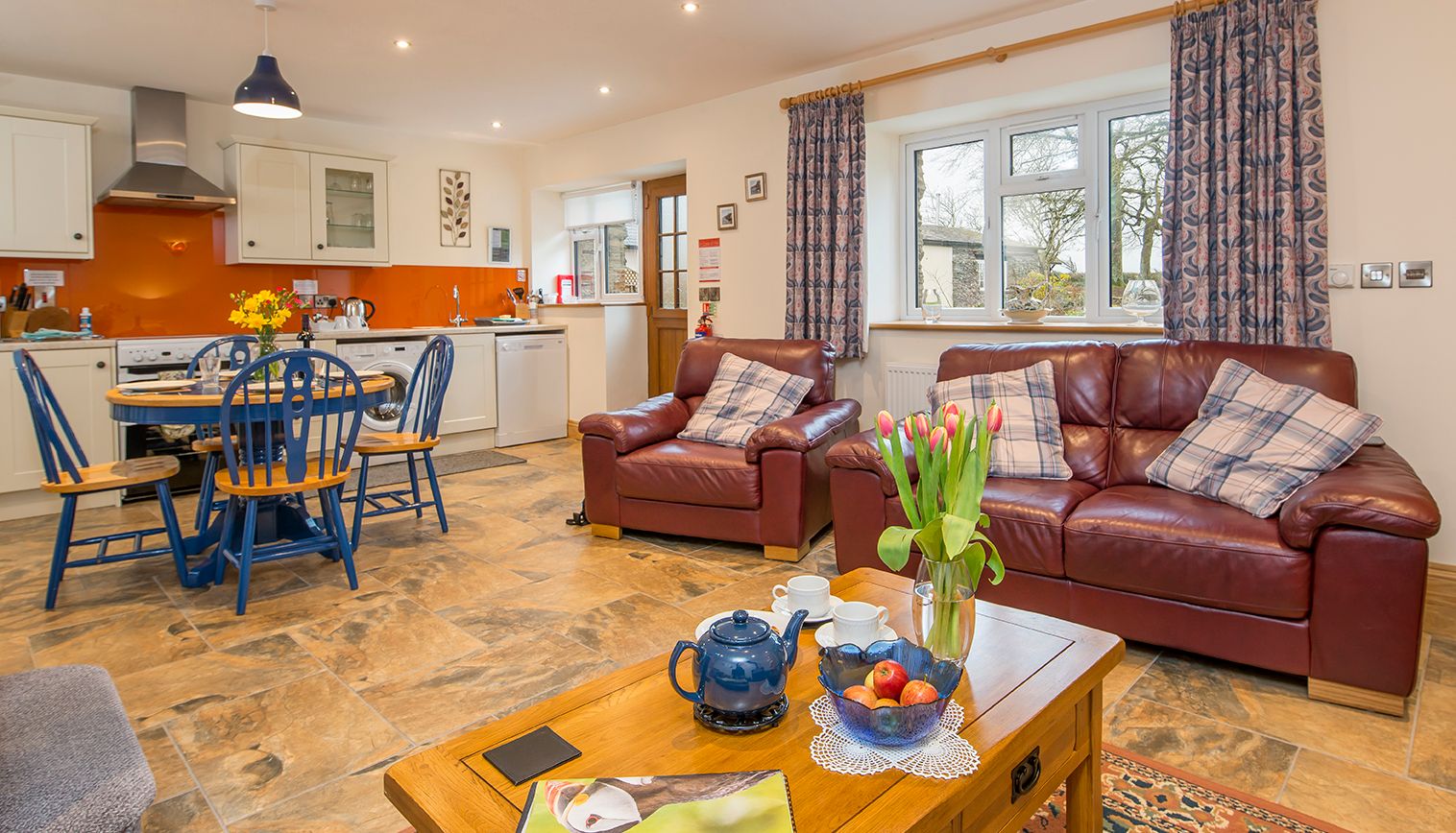 Cych Cottage inside the Living space, with leather sofas, a small round dining table and spacious kitchen