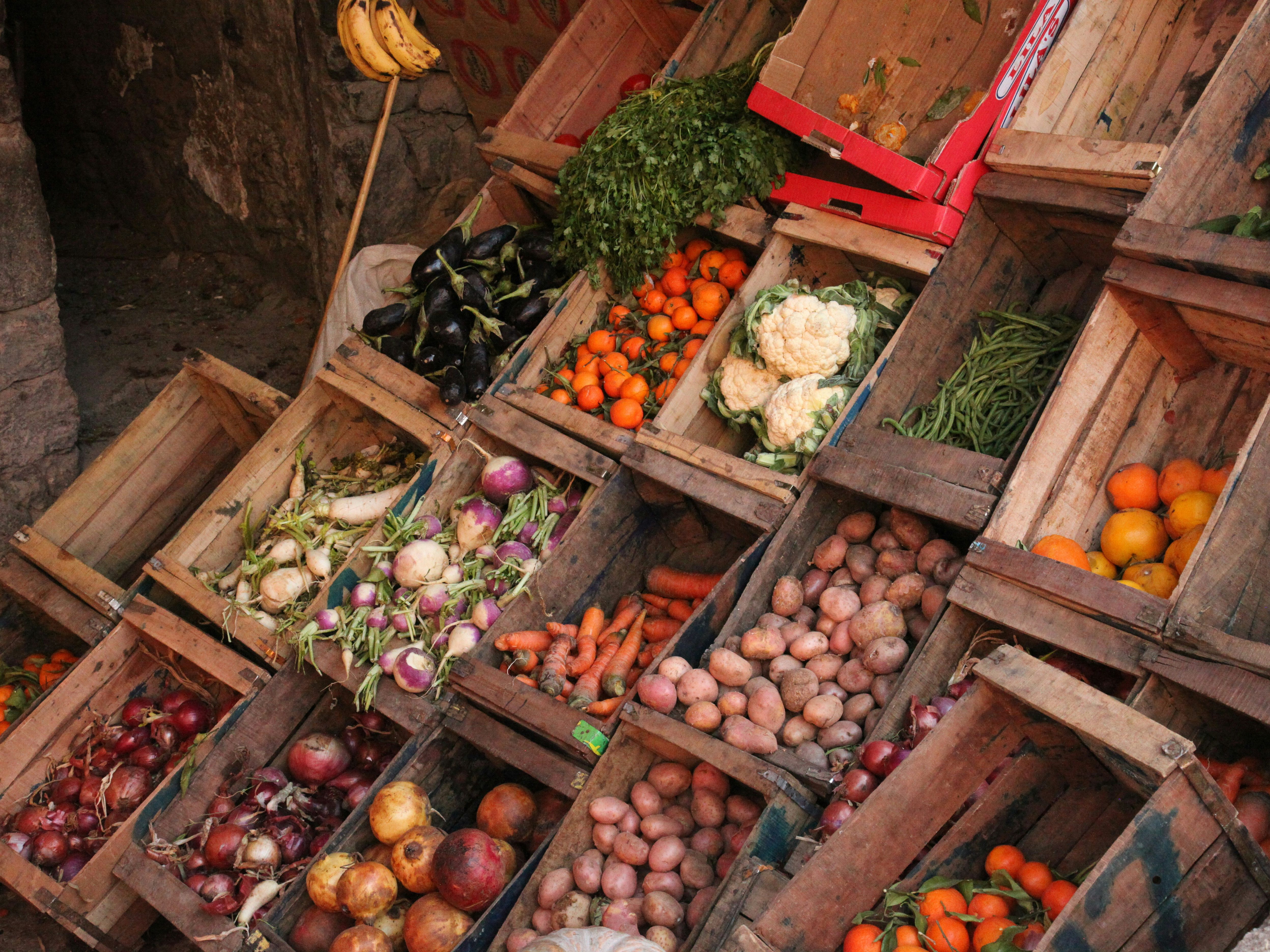 Wooden crates filled with fresh fruit and vegetables at a market stall