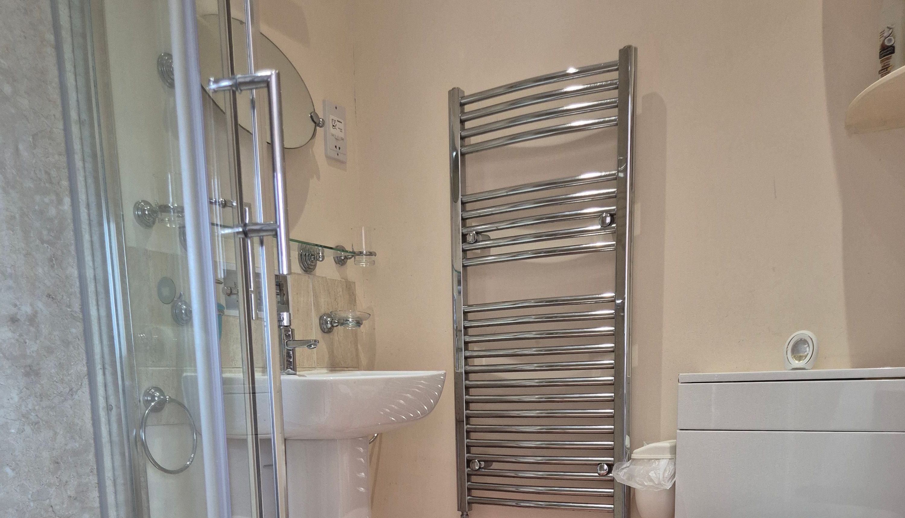 Modern bathroom with shower, toilet, and towel radiator