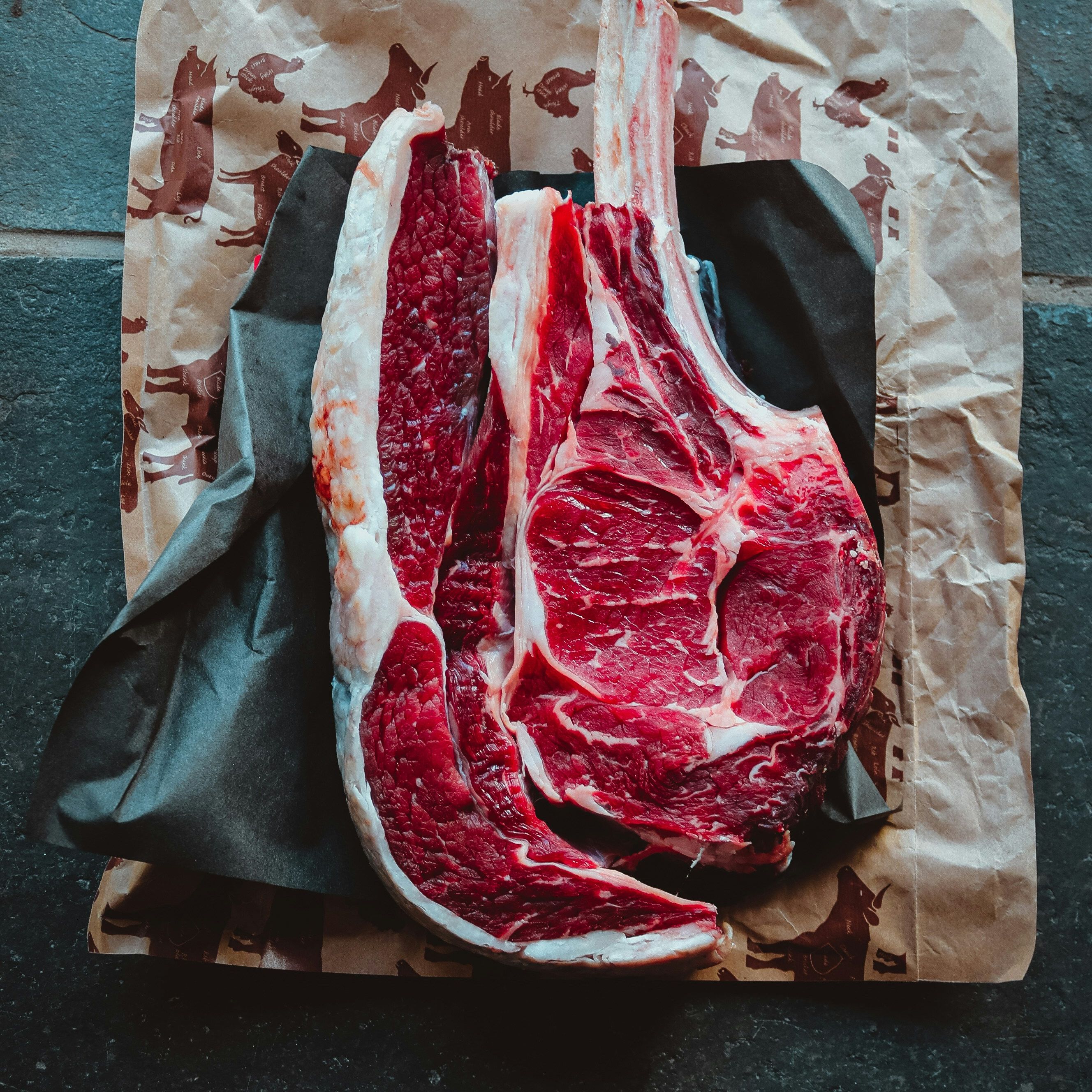 Raw tomahawk steak on butcher paper