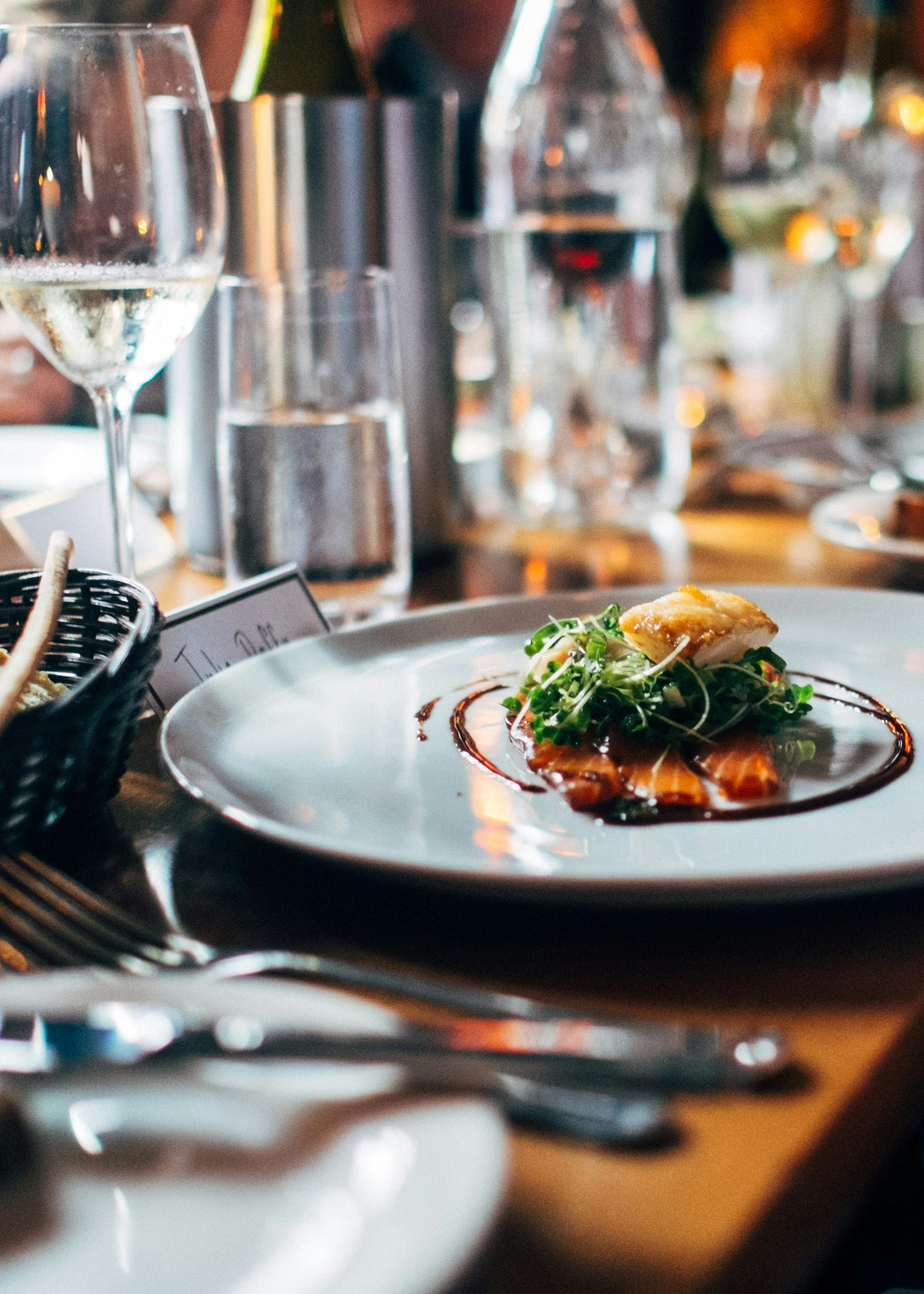 Elegant dinner table with gourmet dish, wine glasses, and bread basket