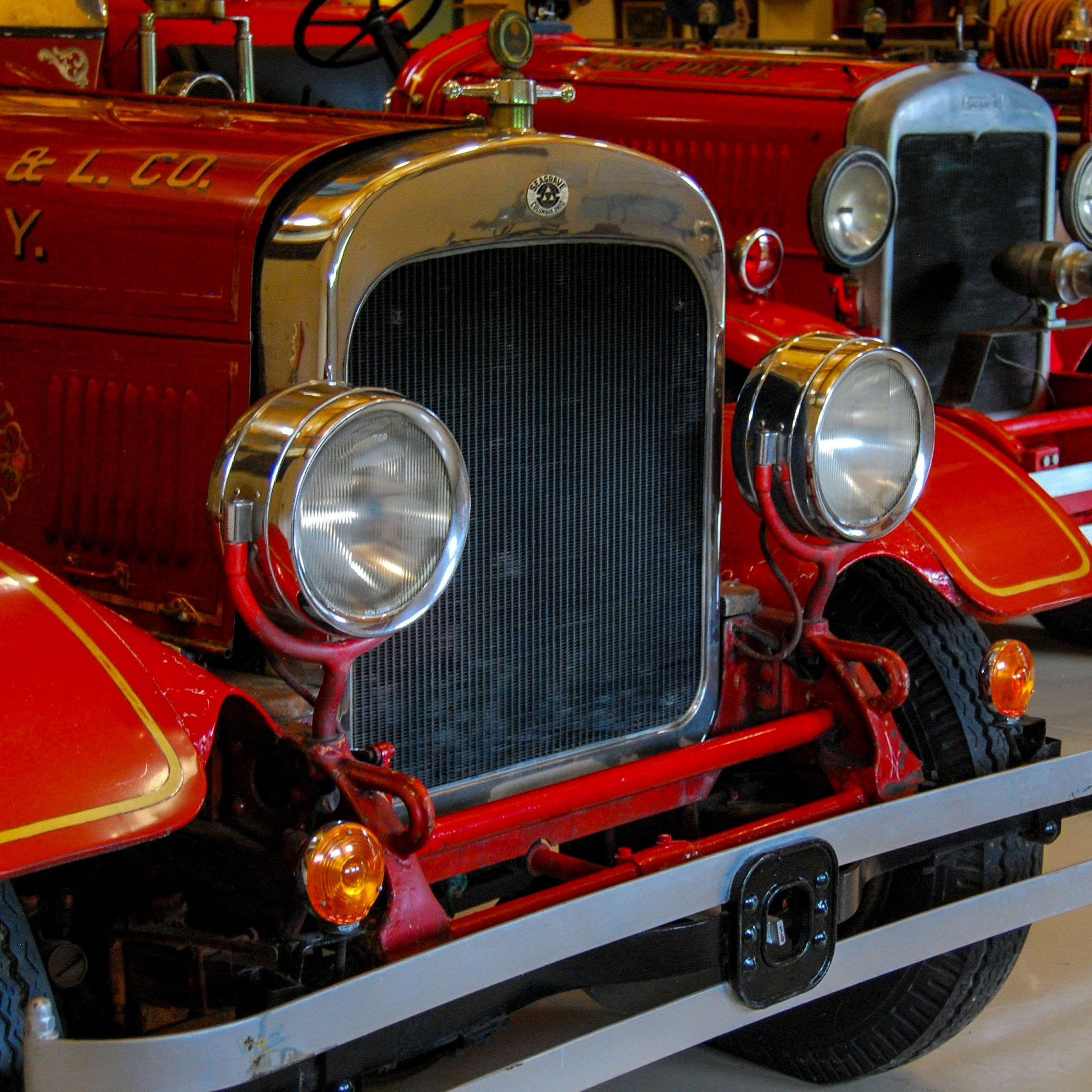 Close-up of vintage red fire trucks on display in a museum.