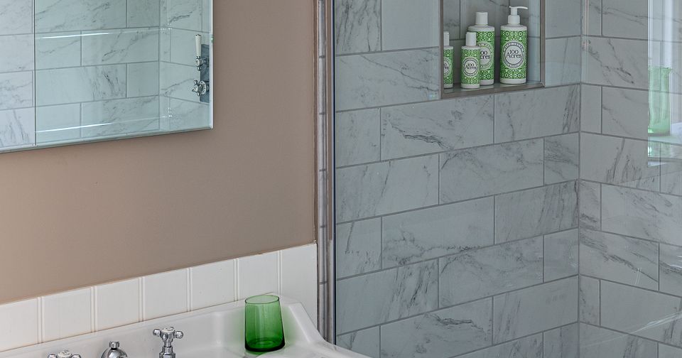Modern bathroom with white sink and marble-tiled shower
