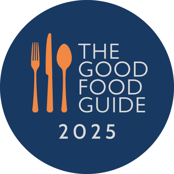 Circular logo for The Good Food Guide 2025 with orange cutlery icons and white text on a dark blue background.