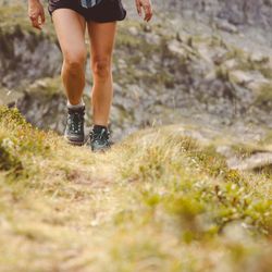 Woman in hiking boots walking up a hill