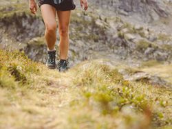 Woman in hiking boots walking up a hill