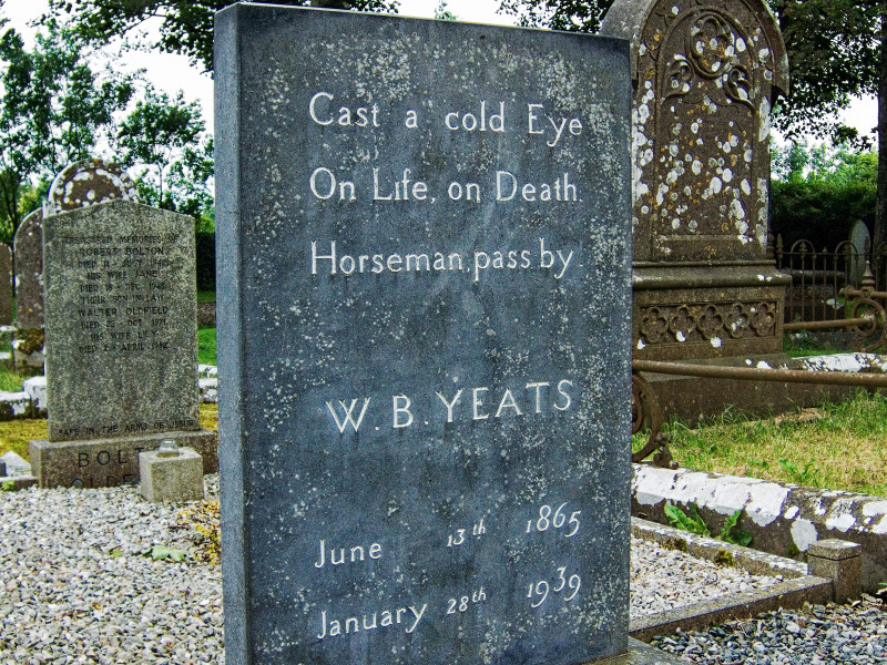Gravestone of Irish poet W.B. Yeats in a cemetery, inscribed with the epitaph: 