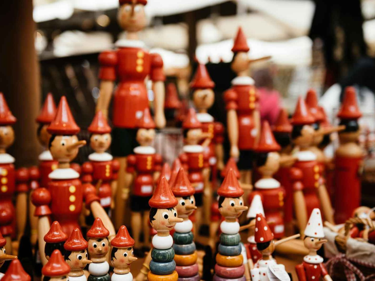 Wooden Pinocchio dolls displayed at a craft stall