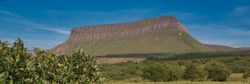 Benbulben, the distinct flat-topped mountain in Ireland, with a verdant landscape beneath.