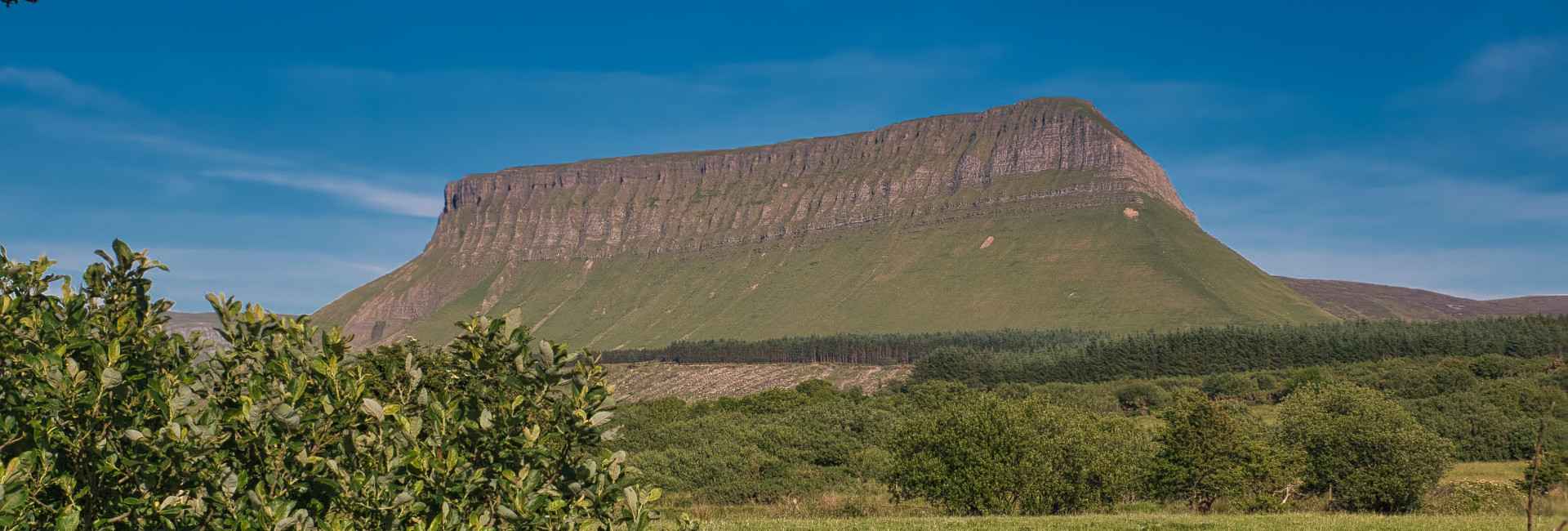 Benbulben, the distinct flat-topped mountain in Ireland, with a verdant landscape beneath.