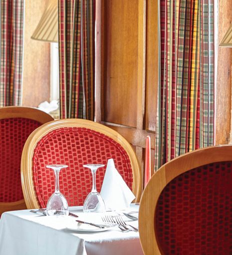 Table of two with white table cloth in the window of the hotel with cloth napkins