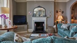 Living room with blue sofa, facing a fireplace