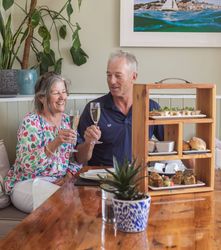 Older couple enjoying afternoon tea and toasting with champagne glasses.