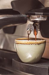 Espresso machine brewing coffee into a cup