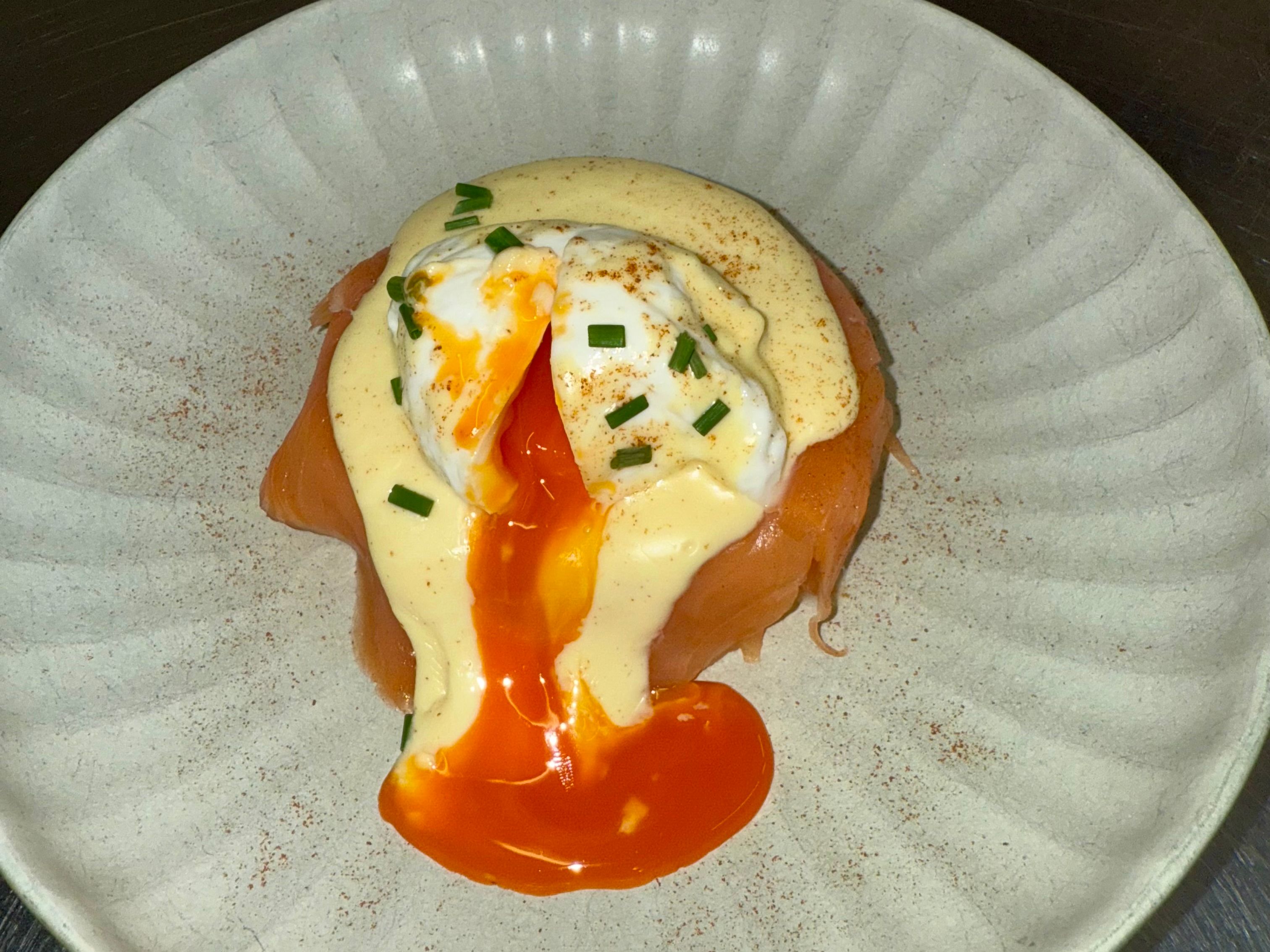 Poached egg with hollandaise sauce and smoked salmon on a plate
