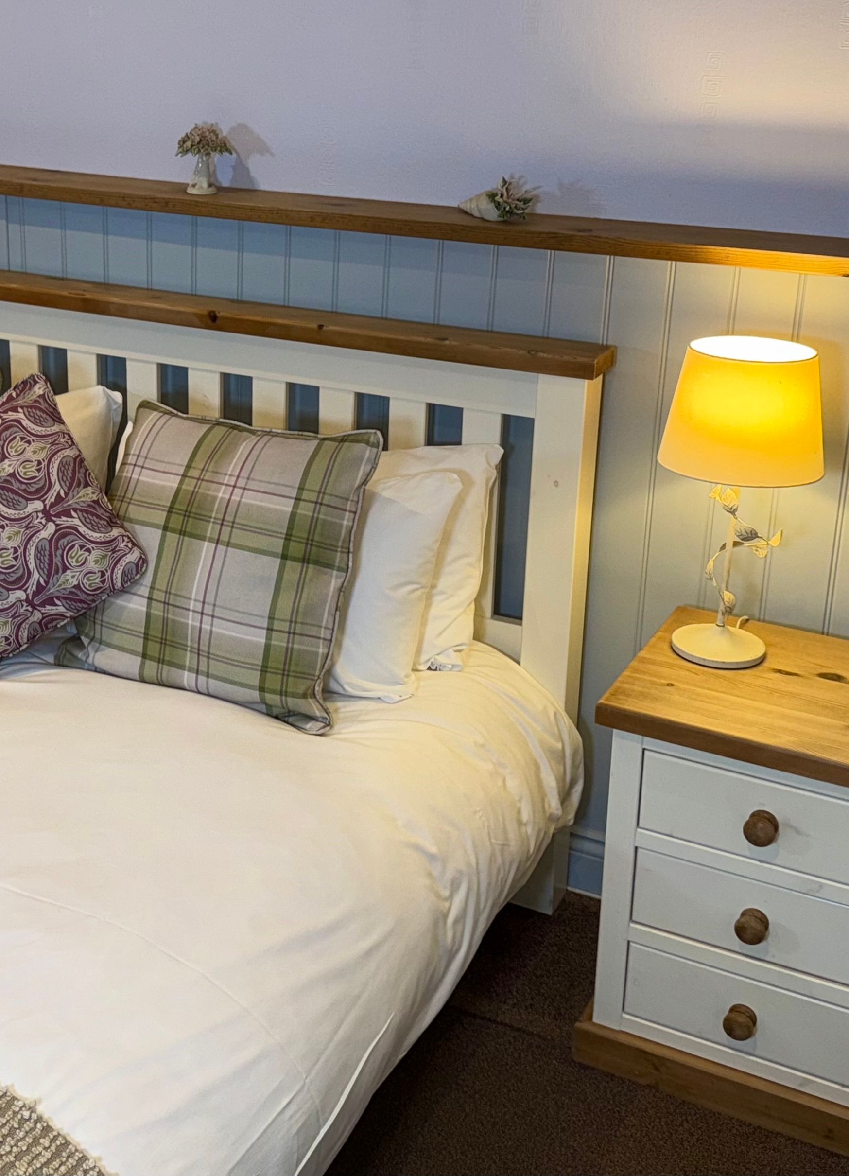 Cozy bedroom with a double bed, bedside tables, lamps, and decorative pillows.