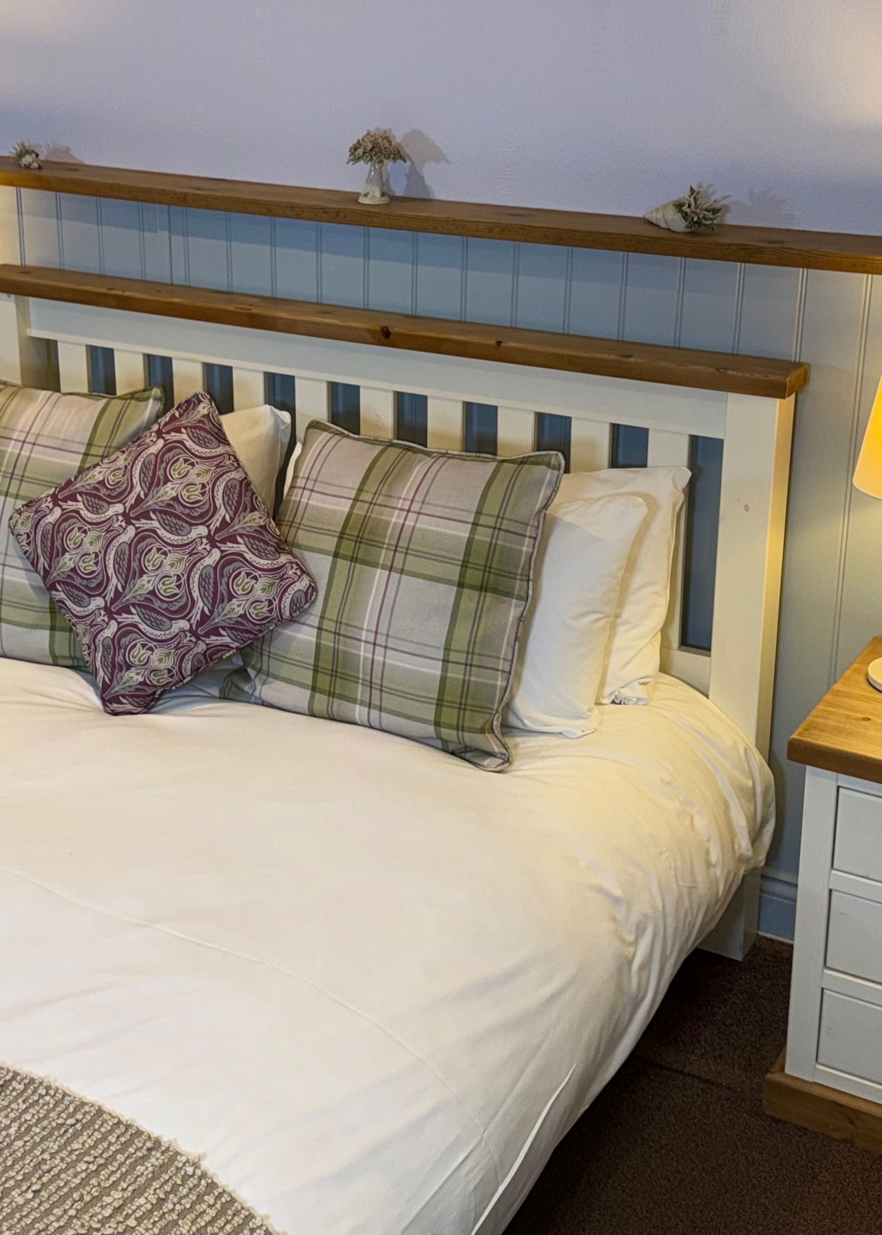 Cozy bedroom with a double bed, bedside tables, lamps, and decorative pillows.