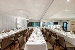 Elegant wedding reception room with tables set for dinner and large illuminated LOVE sign.