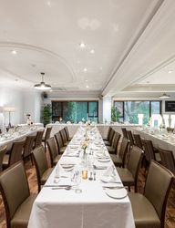 Elegant wedding reception room with tables set for dinner and large illuminated LOVE sign.