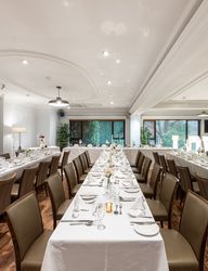 Elegant wedding reception room with tables set for dinner and large illuminated LOVE sign.