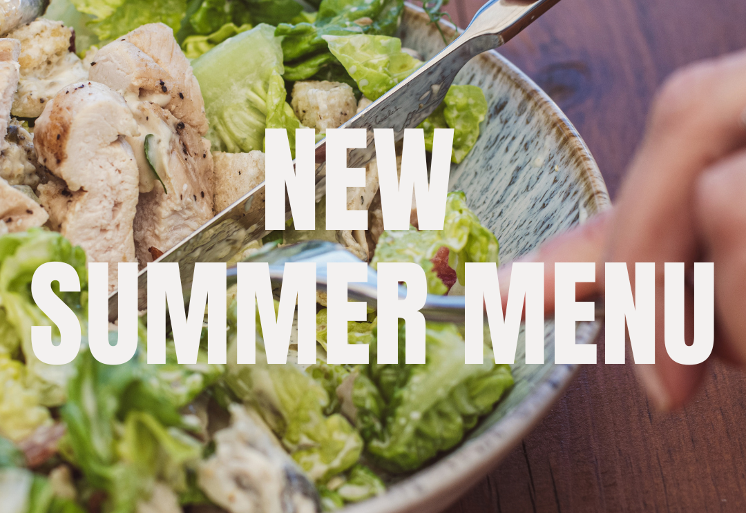 Hands using cutlery to eat a chicken salad with lettuce and croutons, overlaid with the text 