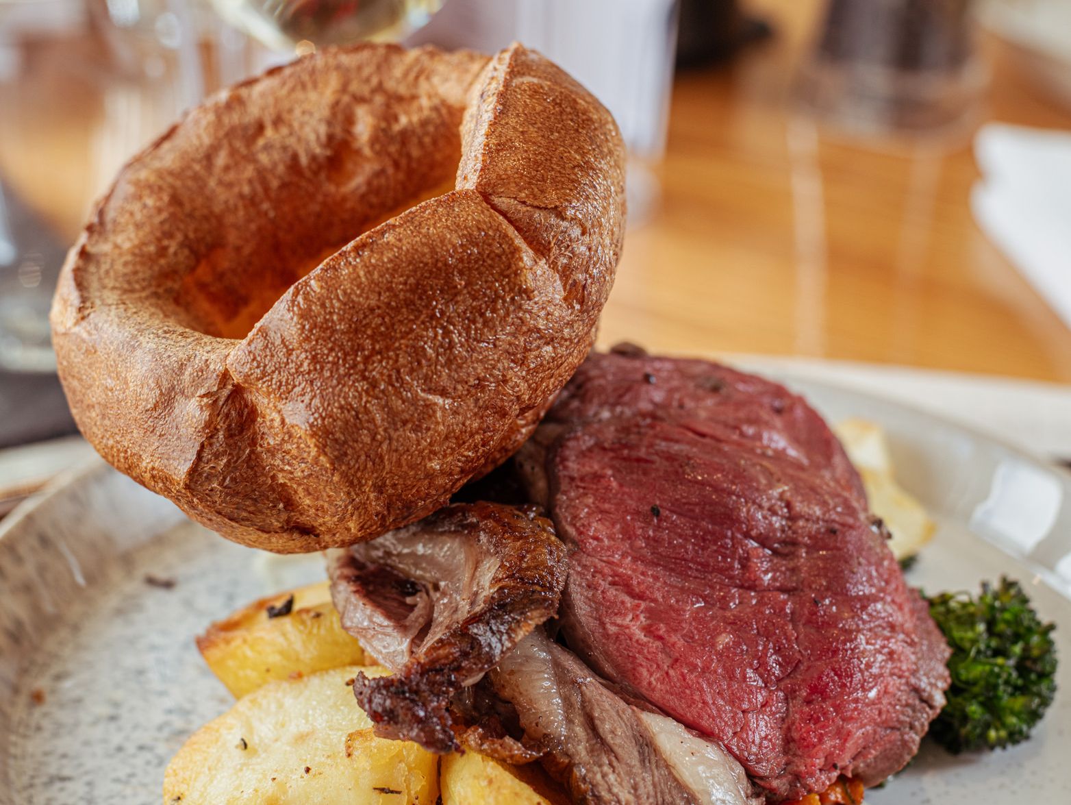 Yorkshire pudding with roast beef, roast potatoes and gravy on a plate