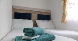 Twin beds with blue towels