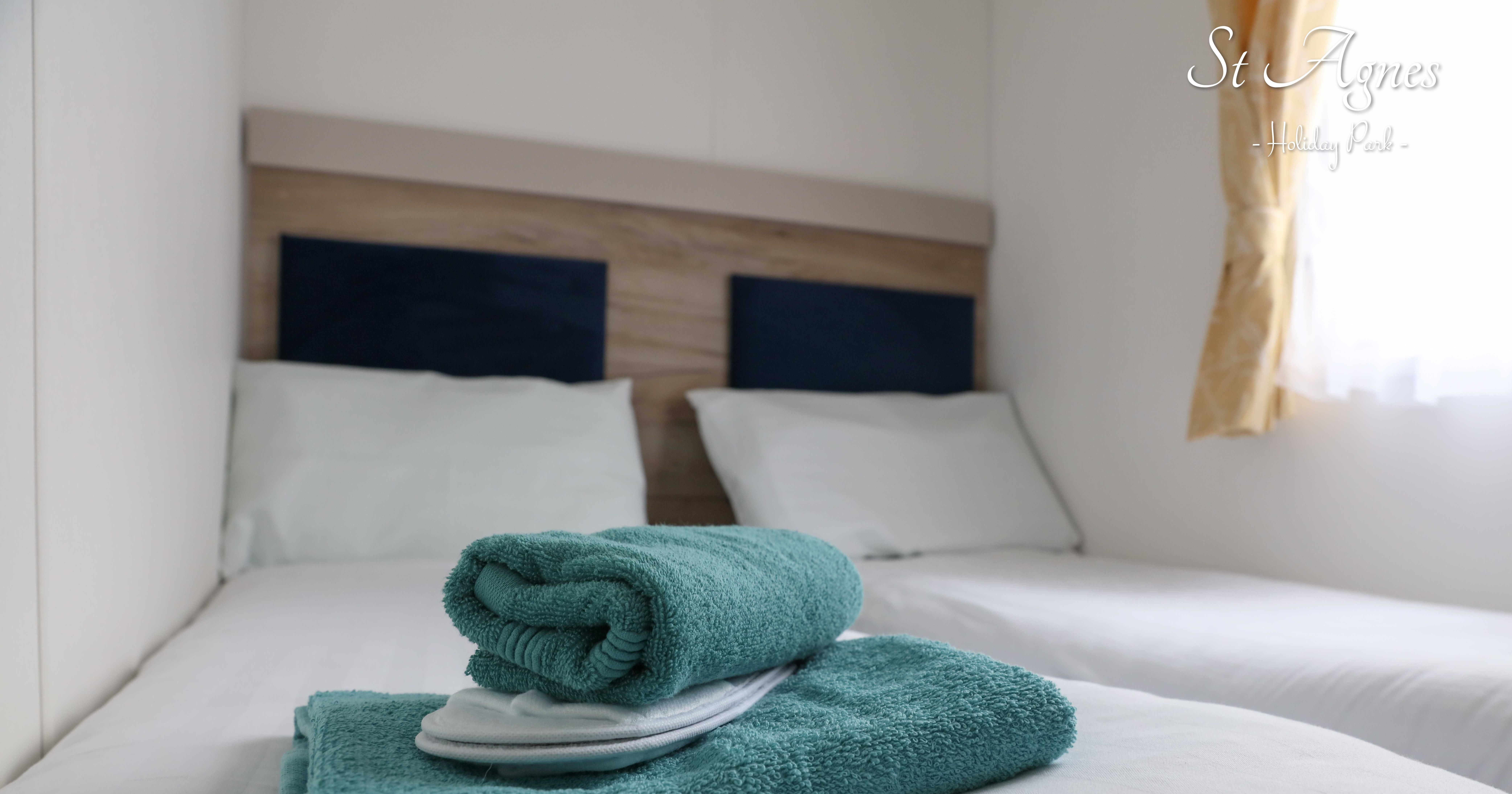 Twin beds with blue towels