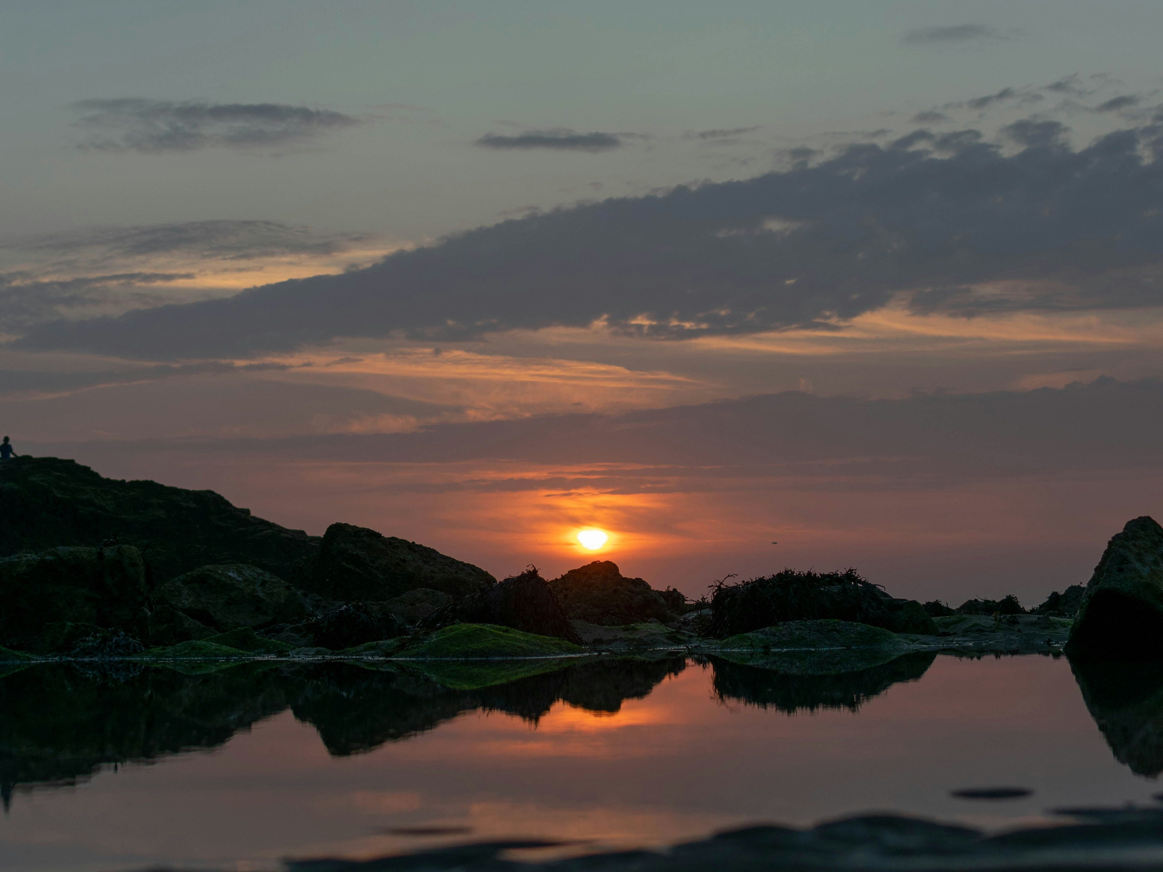 Sunset over rocks with reflection in water