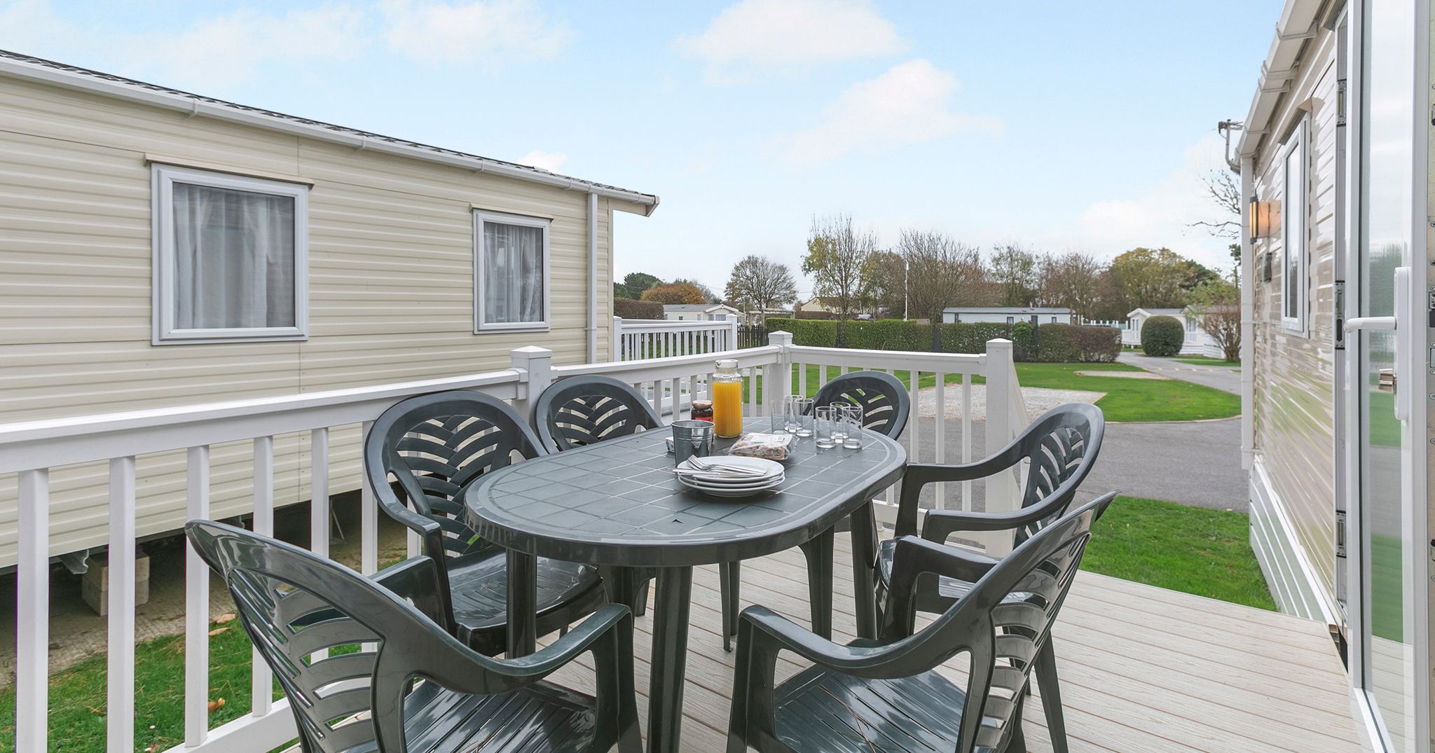 Outdoor dining area on a deck beside a mobile home