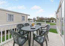 Outdoor dining area on a deck beside a mobile home