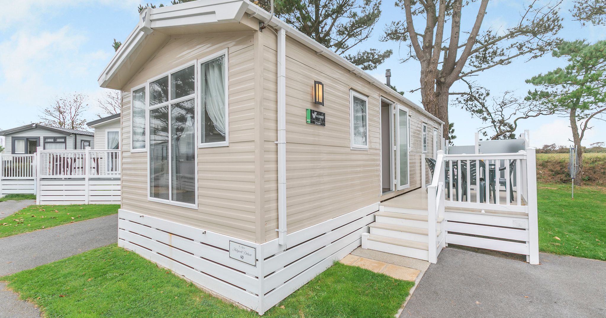 Modern beige mobile home with white trim and a small porch