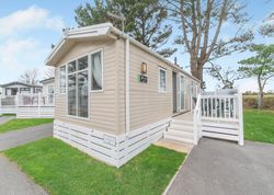 Modern beige mobile home with white trim and a small porch