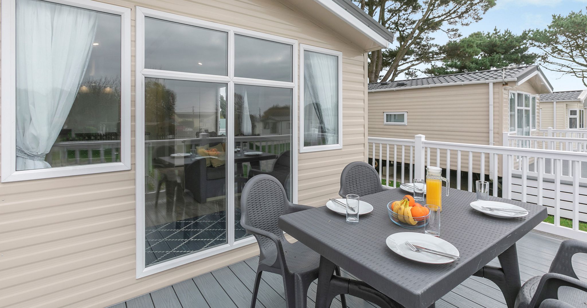 Outdoor dining setup on the deck of a modern mobile home
