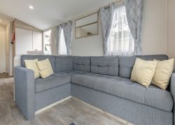 Modern living room with a grey sectional sofa and light-colored cushions.